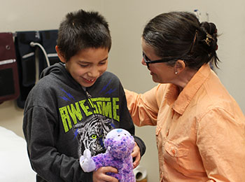 A health care staff is taking special care to meet the health care needs of a male Native American student.