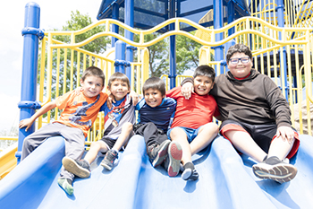 Campers huddle together with big smiles, capturing a moment of friendship at Rising Eagle Day Camp.