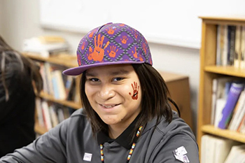 A St. Joseph’s Indian School student smiles while wearing his temporary red handprint tattoo in honor of Missing and Murdered Indigenous Relatives (MMIR) Day.