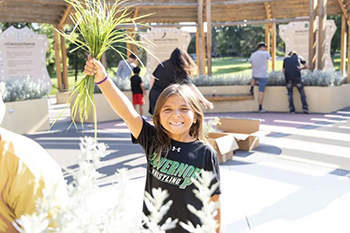 A St. Joseph’s Indian School student proudly holds up her freshly cut sweetgrass.