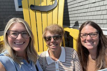 Barbara (middle) smiles with St. Joseph’s Indian School employees as they discuss how IRA gifts help Lakota (Sioux) children thrive.