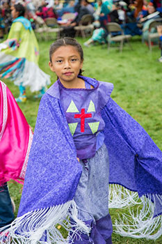 A young Native American girl wears purple regalia at St. Joseph’s powwow. According to powwow etiquette, one should ask permission before touching any part of a dancer’s regalia.