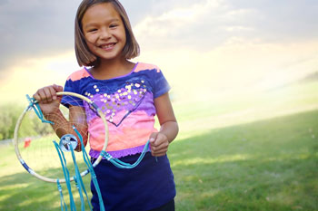 Lakota girl holding a colorful dreamcatcher.