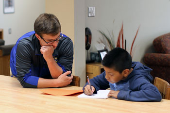 St. Joseph's staff member helping a Lakota boy with his homework.