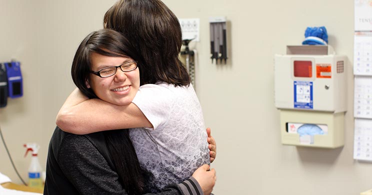 Nurse Nancy hugging a Lakota child during a routine check-up.